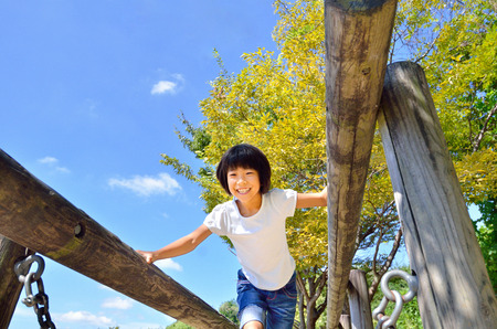 A girl playing at the playground in the Parkの写真素材