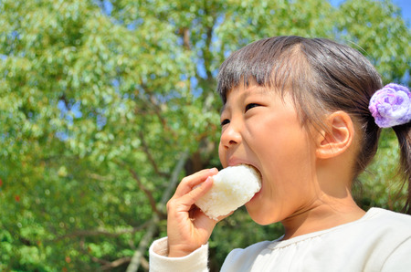 Girl eating rice ballsの写真素材