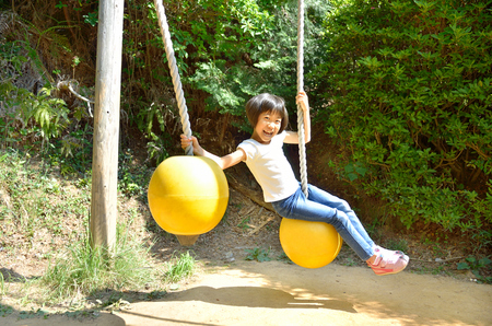 A girl playing at the playground in the Parkの写真素材