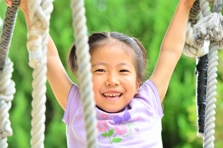 A girl playing at the playground in the Parkの写真素材