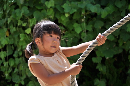 A girl playing at the playground in the Parkの写真素材