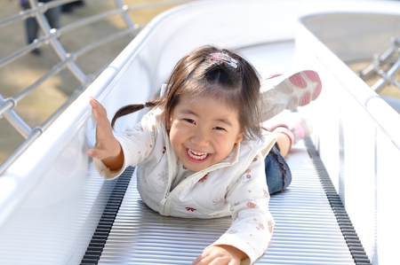 A girl playing at the playground in the Parkの写真素材