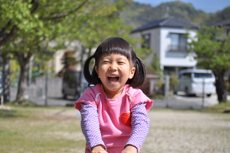 A girl playing at the playground in the Parkの写真素材