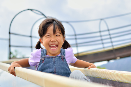 A girl playing at the playground in the Parkの写真素材