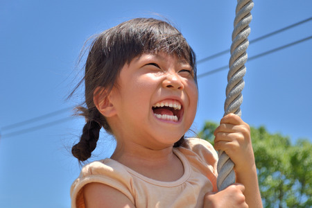 A girl playing at the playground in the Parkの写真素材