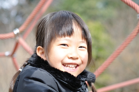 A girl playing at the playground in the Parkの写真素材