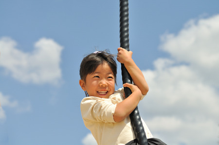 A girl playing at the playground in the Parkの写真素材