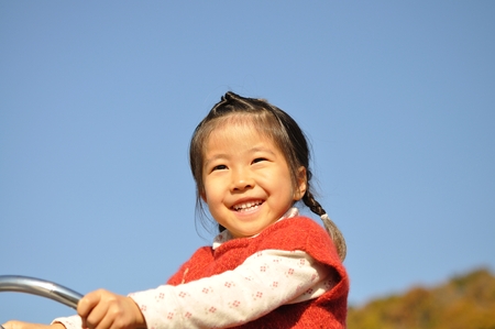 A girl playing at the playground in the Parkの写真素材