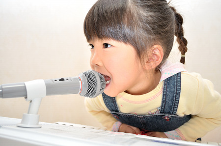 Girl singing in a microphoneの写真素材