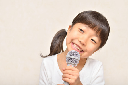 Girl singing in a microphoneの写真素材