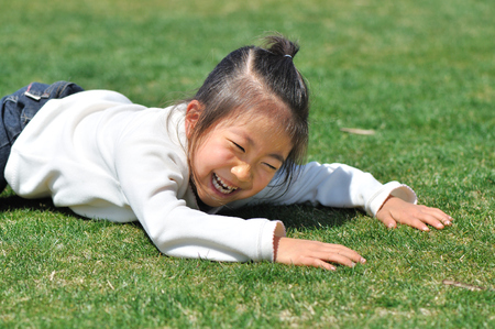 Girls lie down in the grassの写真素材
