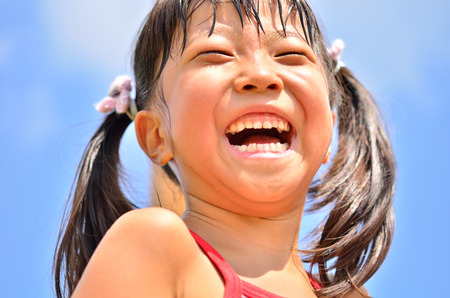 Girls laughing in the blue skyの写真素材