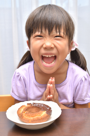 Girl eating delicious Donutの写真素材