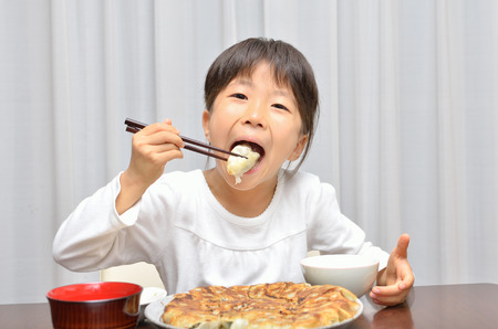 Girls eat delicious chinese dumplingsの写真素材