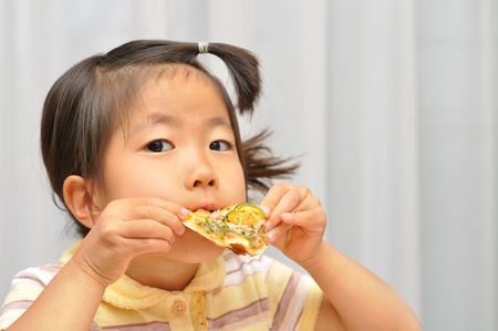 Girl eating delicious pizzaの写真素材
