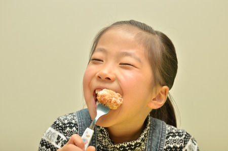 Girl eating the delicious fried chickenの写真素材