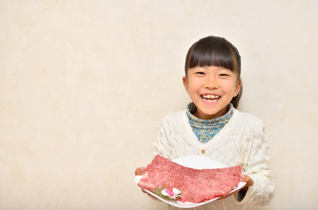 Girls giving meat for Sukiyakiの写真素材