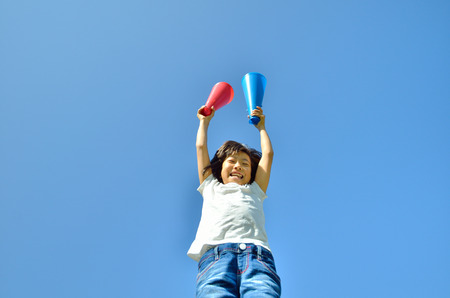 Girls cheer in the blue sky (megaphone)の写真素材