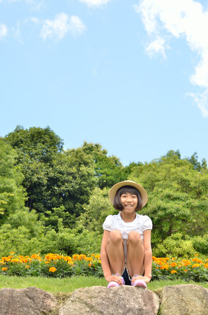 Girl smile in the flower garden (straw hat)の写真素材