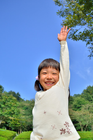 Girls raise hand in the blue skyの写真素材
