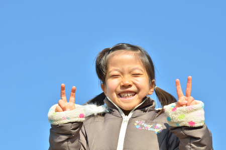 Girls fork her fingers in the blue skyの写真素材