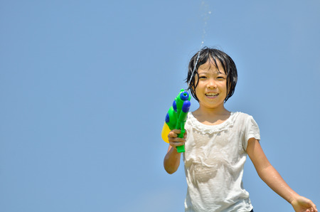 Girl playing with water pistolsの写真素材