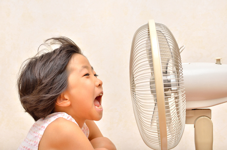 Girls cooled down by the electric fanの写真素材