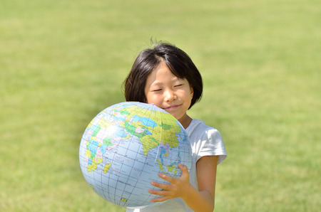 Girls hold earth in the grasslandの写真素材