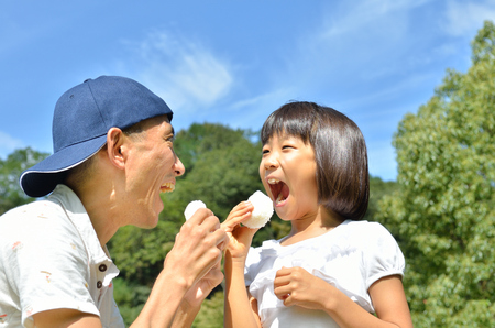 Japanese parent and child eat rice ballの写真素材