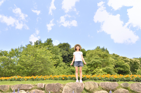 Girls smiling in the flower garden (straw hatの写真素材