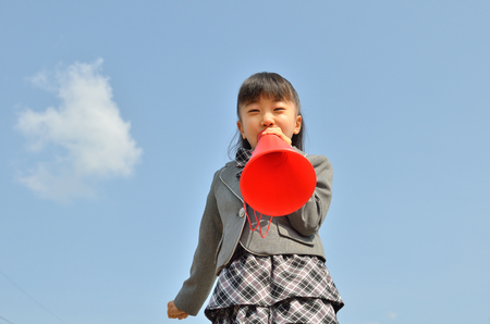 The first grade girl cheering in the blue skyの写真素材