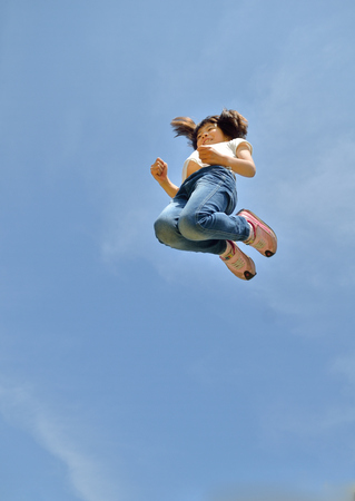 Girls jumping in the blue skyの写真素材