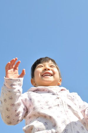 Girl's smiling in the blue skyの写真素材