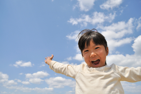 Girl's smiling in the blue skyの写真素材