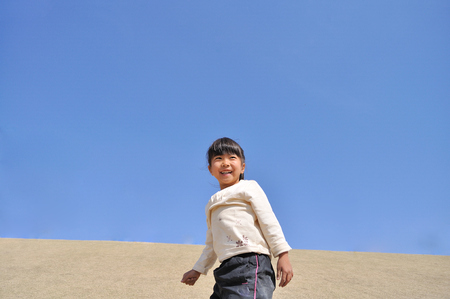Girl's smiling in the blue skyの写真素材