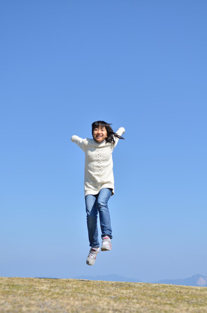 Girl's jumping in the blue skyの写真素材