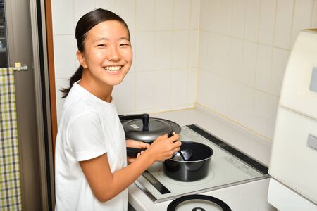 Japanese girl enjoys cooking in the kitchenの写真素材