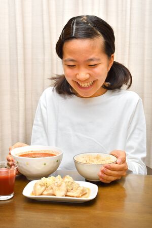 Japanese girl enjoys having dinnerの写真素材