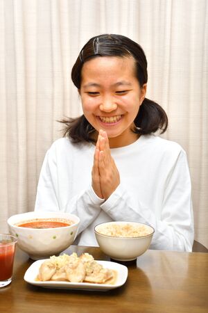 Japanese girl enjoys having dinnerの写真素材