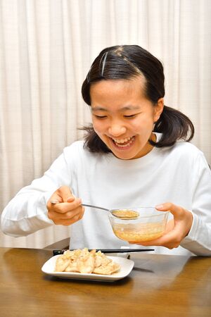 Japanese girl enjoys having dinnerの写真素材