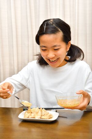 Japanese girl enjoys having dinnerの写真素材