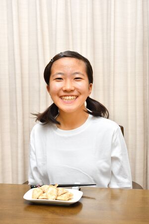 Japanese girl enjoys having dinnerの写真素材