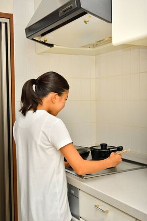 Japanese girl enjoys cooking in the kitchenの写真素材