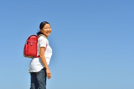 Japanese Elementary School Girl smiling in the Blue Skyの写真素材