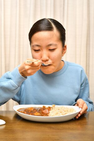 Japanese girl enjoys having curry and riceの写真素材