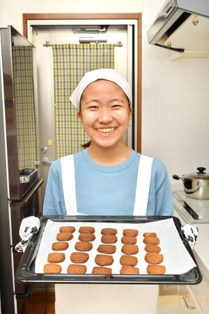 Japanese girl enjoys baking cookiesの写真素材