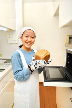 Japanese girl enjoys baking breadの写真素材