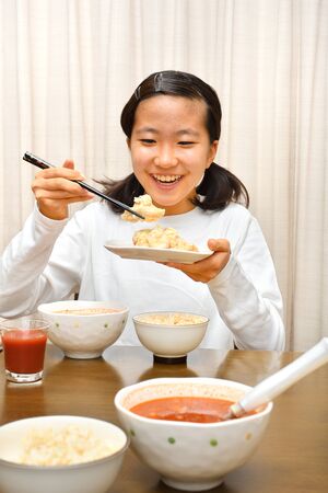 Japanese girl enjoys having dinnerの写真素材