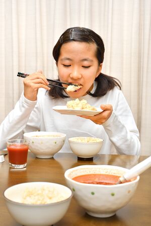 Japanese girl enjoys having dinnerの写真素材