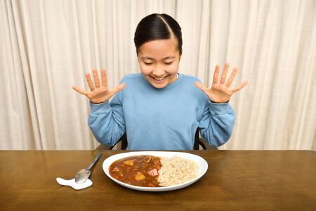 Japanese girl enjoys having curry and riceの写真素材